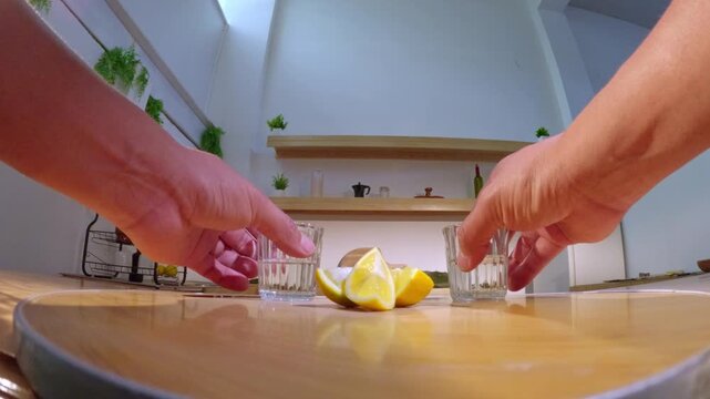 People pouring mezcal into glasses with lemons