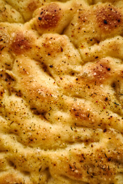 Close-up of golden focaccia flatbread with herbs and salt