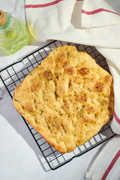 Homemade focaccia flatbread cooling on wire rack