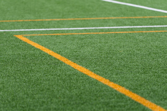 Close-up of green artificial turf with painted field lines