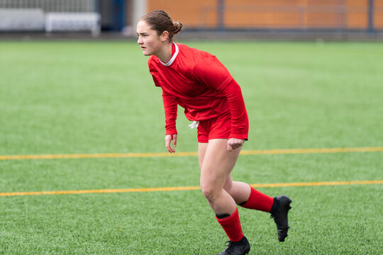 Female soccer player in red kit during competitive match