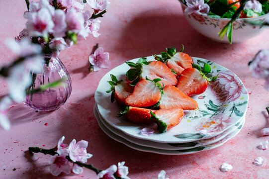 Spring strawberry still life with blossom on pink table