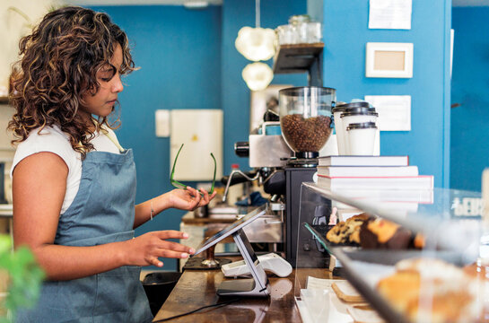 Woman working in a trendy coffee shop using digital tablet