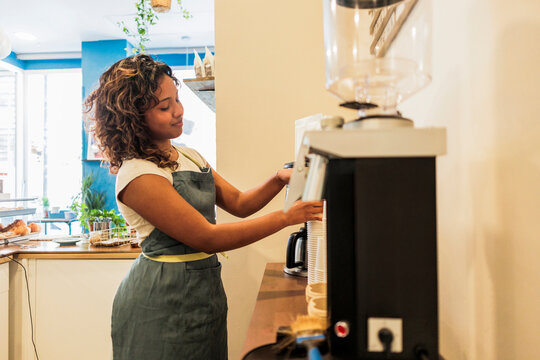 Woman barista preparing coffee in a modern cafe