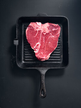 Raw t-bone steak on grill pan ready for home cooking