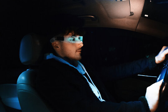 Man driving at night with cyber visor and digital HUD