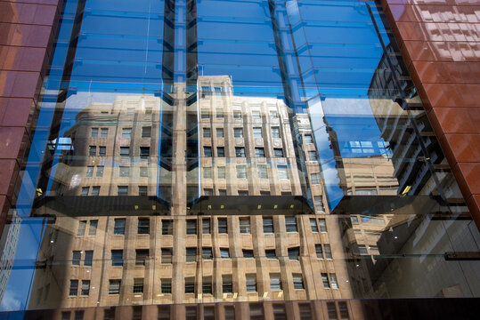 Reflection of old, sandstone building in a modern glass facade