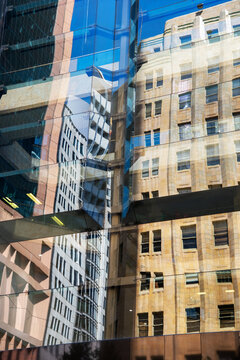 Reflection of old, sandstone building in the glass of a modern building