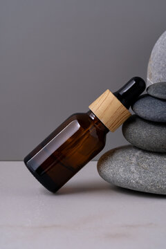 Cosmetic dropper bottle on smooth stones in spa setting