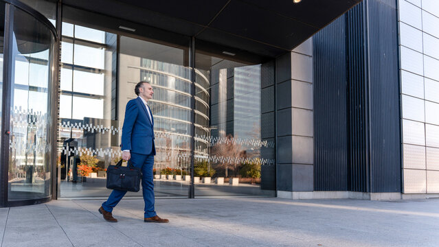 Businessman walking outside modern office building