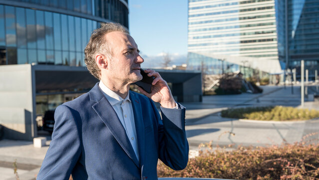 Middle-aged businessman on phone in urban setting