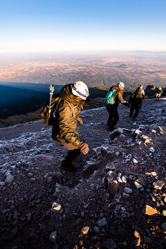 Hikers climbing A rocky mountain slope at sunrise