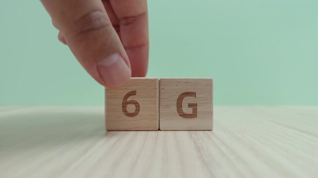 Hand replacing wooden block with number 5 for number 6 next to letter G on wooden table, Concept of 6G network technology transition and future of mobile communication