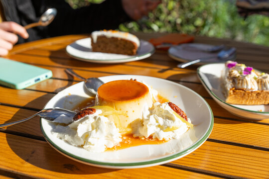 Caramel flan dessert with cream served on sunny terrace