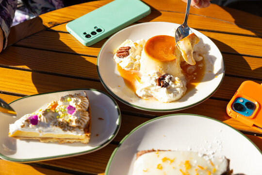 Outdoor terrace dessert with flan and cake in sunlight