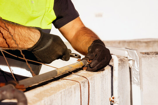 Industrial maintenance technician repairing piping with plier