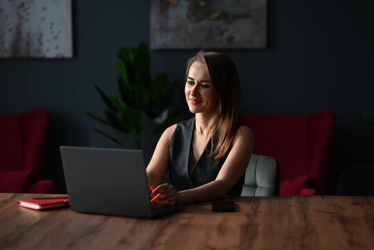 Focused business woman working on laptop in modern office