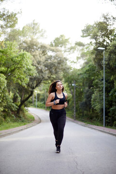 Young woman jogging on park road for fitness training