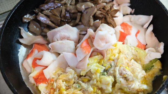 Street food delight: sizzling wok-tossed crab sticks and fish sticks with mushrooms, eggs and fresh vegetables. A quick, flavorful bite bursting with Asian-inspired flavors