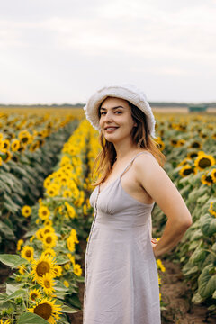 Woman in sunflower field wearing sun hat in summer