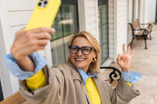 Woman taking selfie outdoors smiling confidently