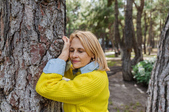 Woman embracing nature with peaceful expression outdoors