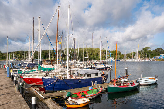 Sailboats and small colorful boats moored at jetty in traditional harbor, Kiel-Friedrichsort, Schleswig-Holstein, Northern Germany