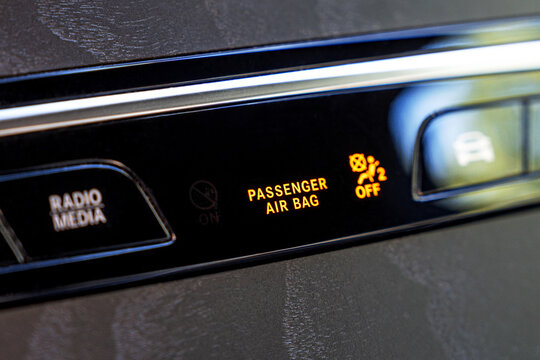 Closeup of passenger airbag warning light on car dashboard