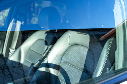 Modern car interior seen through windshield with reflections