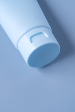 Minimal cosmetic cream tube cap closeup on pastel blue