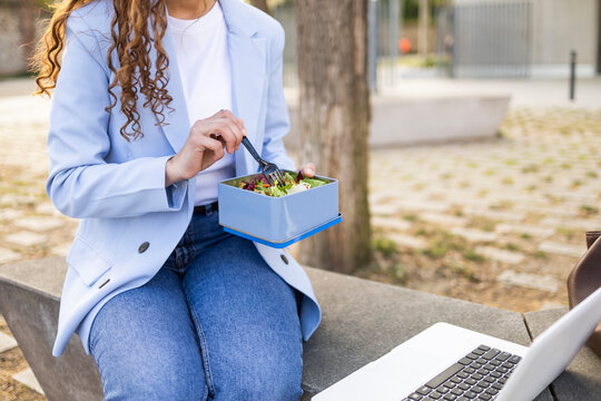 Businesswoman eating healthy lunch while working outdoors