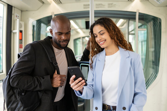 Business couple checking smartphone while commuting by train