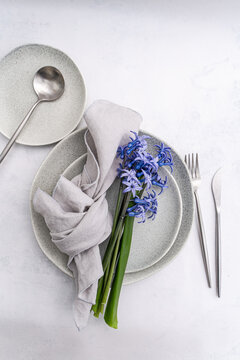 Minimal table setting with blue hyacinth and linen napkin