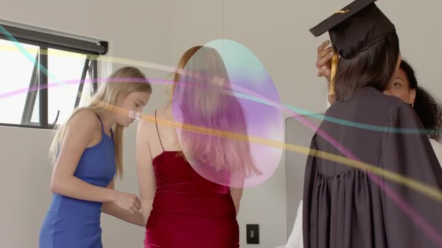 Capped grad entering, women helping don gowns and preparing for graduation, pastel orb overlaying