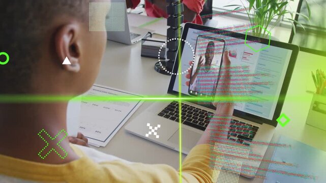 Person in yellow raising phone to laptop aligning live call for business meeting green HUD sweeping