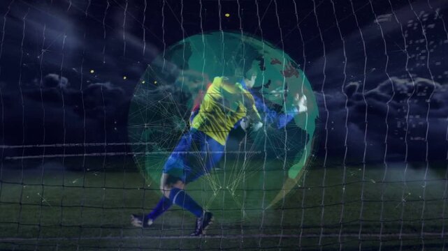 Goalkeeper diving and reaching after attacker striking ball, rotating globe overlay over net sports