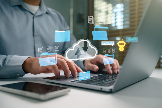 Business person using laptop with cloud storage icons, digital folders, AI chatbot, and document sync interface for data management, file sharing, automation, remote work, and secure online workflow.