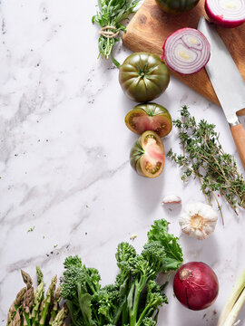 Fresh vegetables and herbs on marble counter for healthy meal