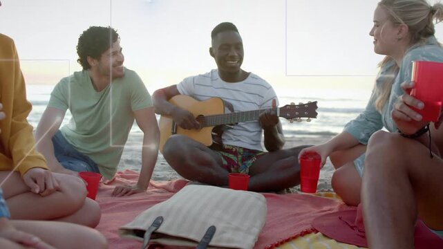 Male guitarist strumming and singing on beach at sunset, animated music notes rising around friends