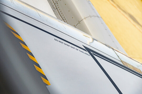Close-up of airplane wing with safety marking and stripe