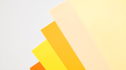 Abstract geometric background with layered paper sheets in yellow and orange tones on a white...