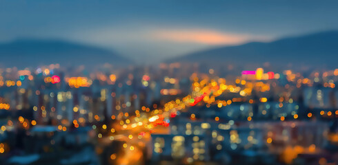Fototapeta premium Blurred cityscape at dusk with illuminated buildings and distant mountains