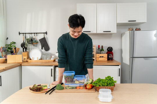 Asian young man cooking healthy foods in kitchen in morning at home. 