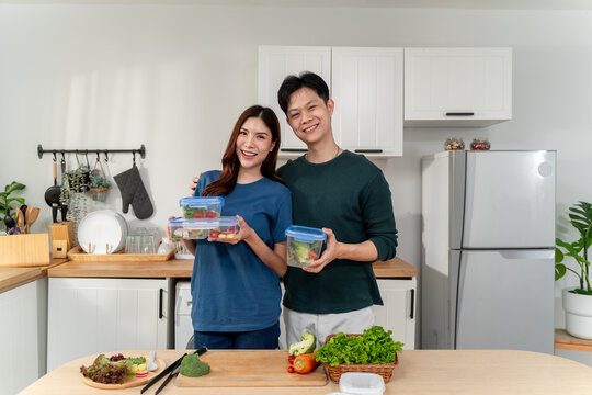 Portrait of Asian young couple spend time together in kitchen at home. 