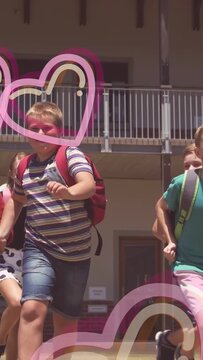 Vertical video: Schoolchildren leaving school and running across lawn, pink hearts overlaying