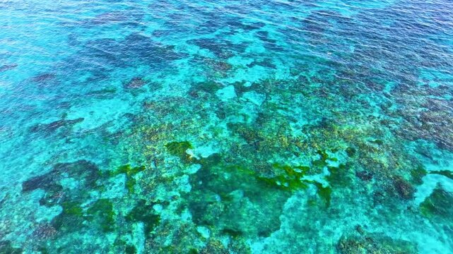 Turquoise seawater and waves 4K background. Atlantic Ocean texture. Sea waves obscure the landscape. Coral shoals. Extensive ocean background with moderate waves, looking straight down.