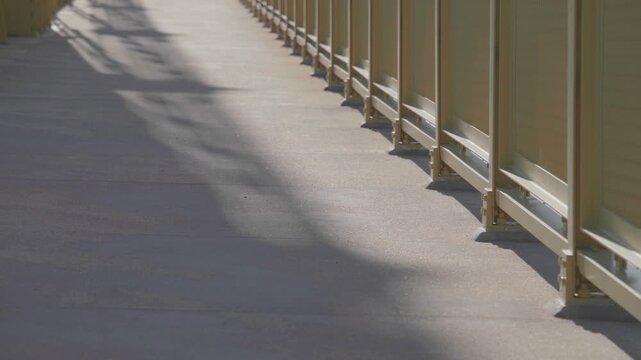 Empty Pedestrian Walkway on Roberto Clemente Bridge with Sunlight Shadows