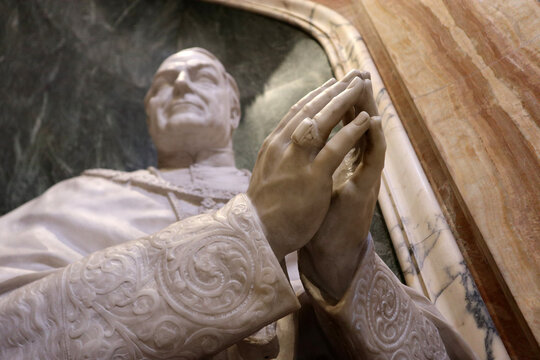 Monumento a Papa Benedetto XV in preghiera, scultura in marmo bianco e bronzo nella Basilica di San Pietro in Vaticano, concetto di pace e fede cattolica