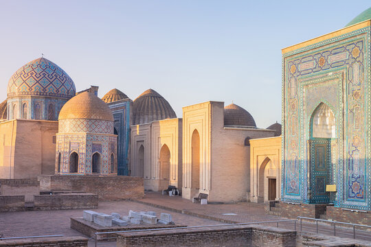 Shah-i-Zinda necropolis mausoleums in Samarkand at golden hour with ornate tilework domes and arched portals. Ideal for travel guides, history publications, and cultural heritage content.