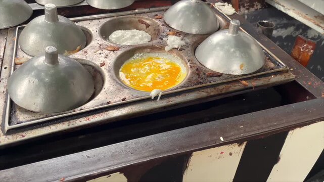 Traditional Indonesian serabi pancakes with oncom and fritters topping being cooked